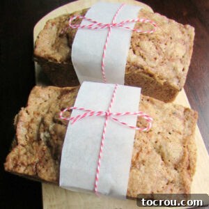 Two small loaves of zucchini bread tied up with parchment paper and baker's twine.