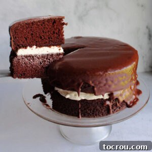 Chocolate Fudge Cream Delight 11 Lifting slice of ding dong cake out of cake, showing chocolate cake layers, creamy vanilla filling and dark chocolate icing.