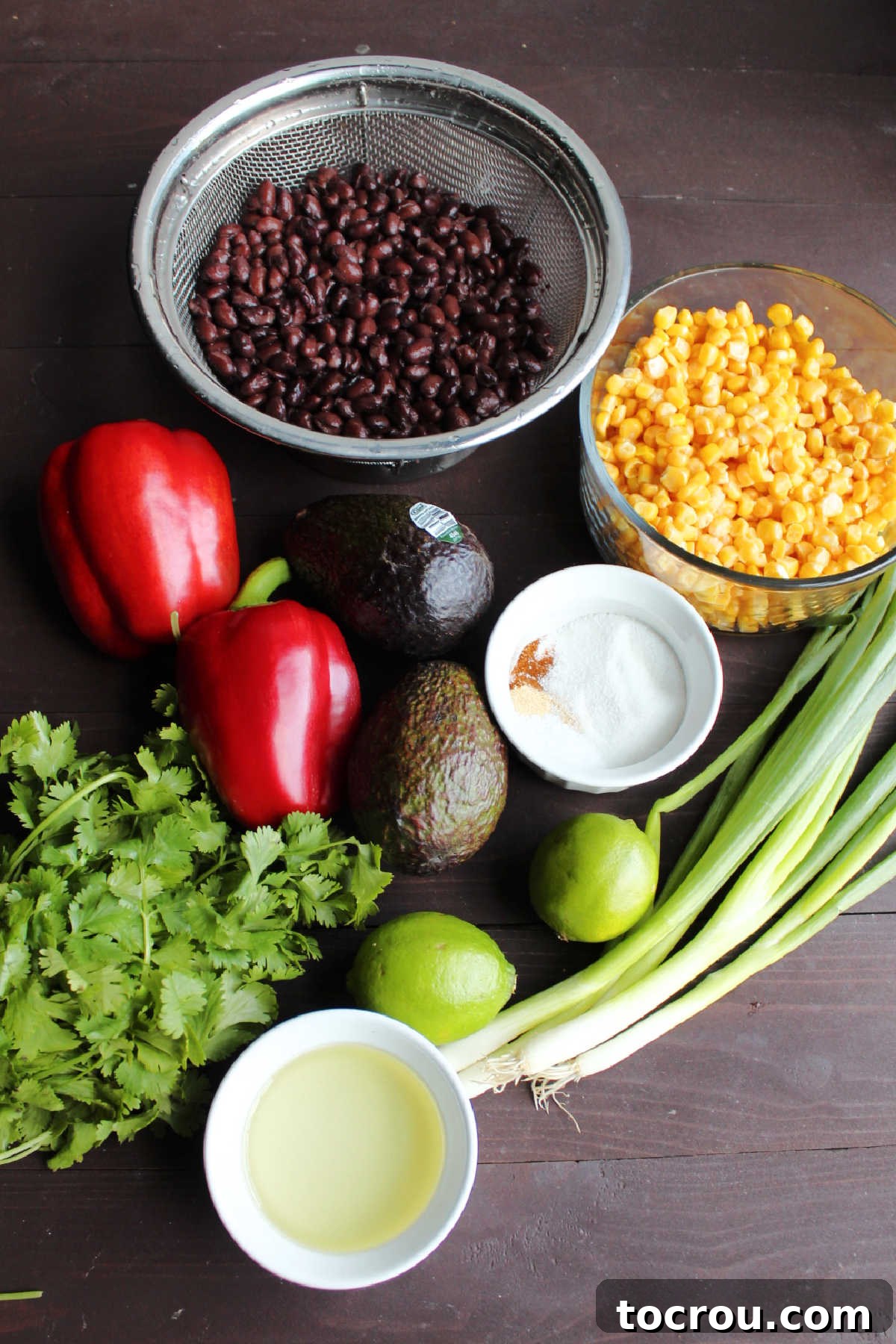 Ingredients: black beans, corn, red pepper, avocados, lime, oil, green onions, cilantro and seasonings ready to be made into salad.