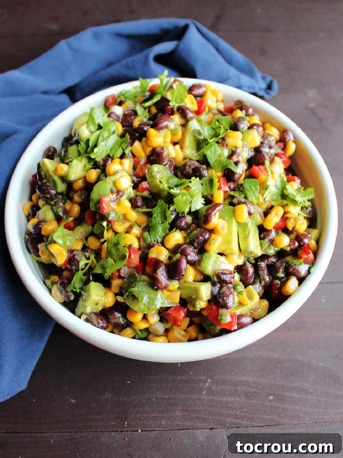 bowl of black bean salad topped with chopped cilantro, ready to serve.