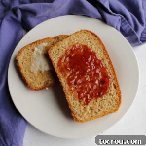 Two slices of toasted sourdough wheat bread on a plate, one with butter and one with honey, representing the recipe's outcome.