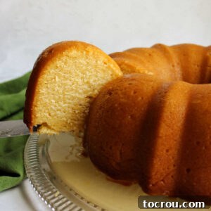 Lifting a slice of honey lemon bundt cake.