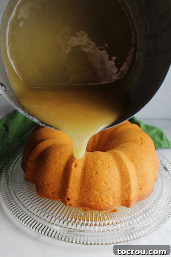 Thick caramelized honey glaze being poured generously over a perfectly baked bundt cake, creating a luscious sheen.