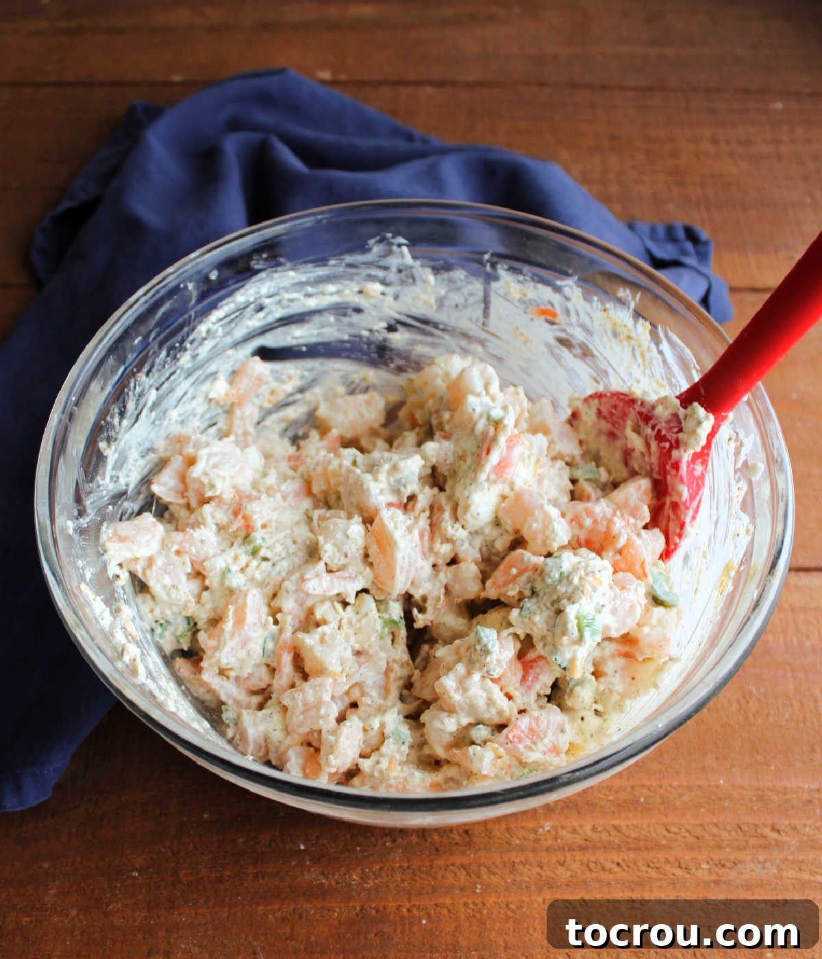 Mixing bowl filled with Cajun shrimp dip, highlighting the generous proportion of large shrimp pieces blended with the creamy cheese base.