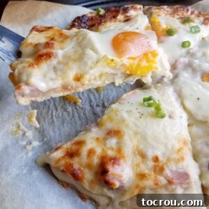Lifting a slice of creamy white pizza with a gooey egg on top, showcasing the melted cheese and rich béchamel.