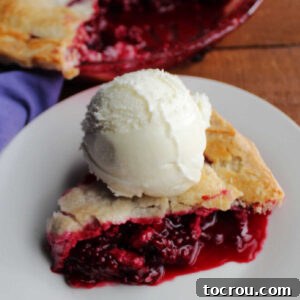 Slice of blackberry pie and ice cream ready to eat.