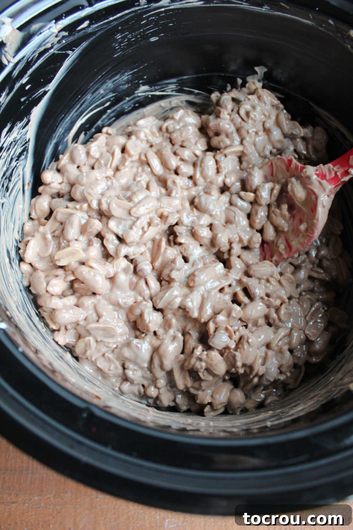 Effortless Crockpot Peanut Delights 5 Melted chocolate and peanut mixture in slow cooker.