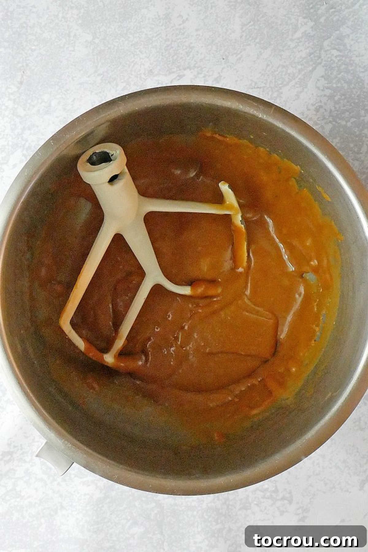 Southern Gold Caramel Frosting 4 Mixer bowl of caramel frosting with paddle, ready for cake.