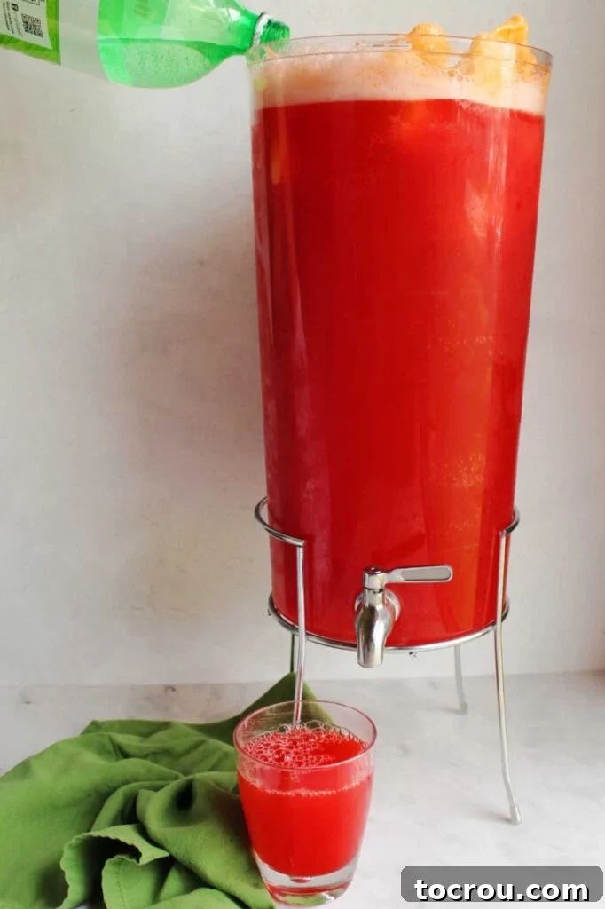 Pouring ginger ale into beverage dispenser filled with colorful punch and orange sherbet.