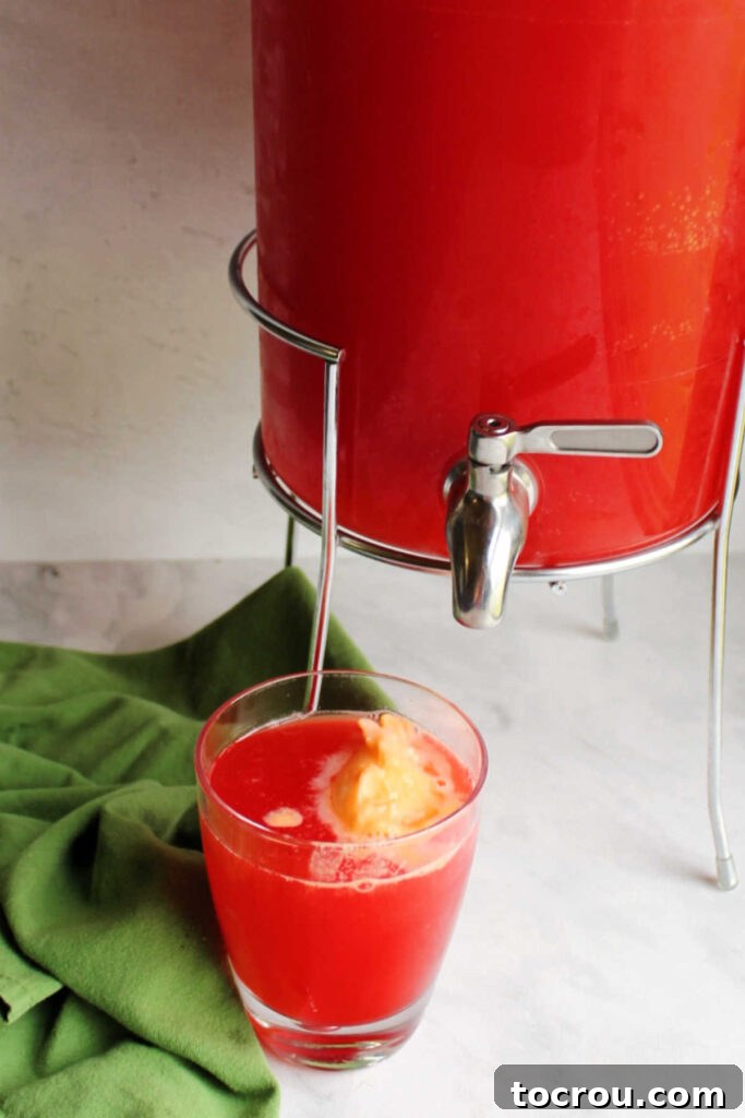 cup of aloha punch with orange sherbet floating in it, ready to drink.