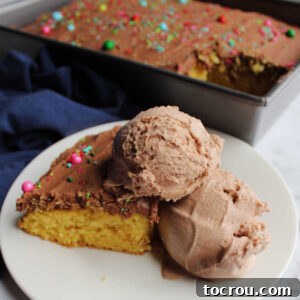 Close piece of cake with chocolate frosting and scoops of brownie batter ice cream ready to eat.