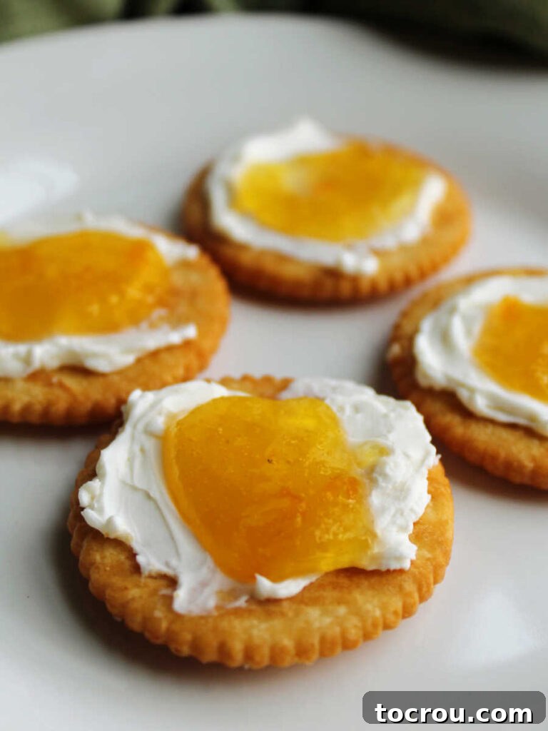 Crackers with a layer of cream cheese topped with peach habanero jelly.