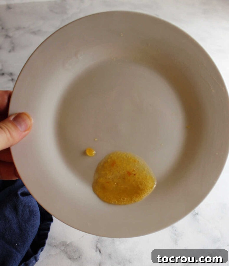 Plate with drop of peach habanero jam chilled in fridge checking final thickness before going into jars.