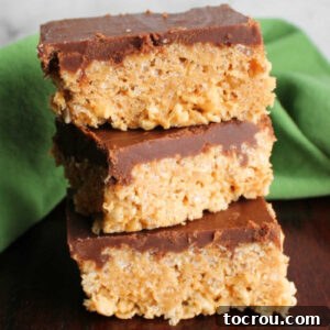 Stack of peanut butter rice Krispie treats topped with hardened homemade fudge icing, indicating perfect setting.
