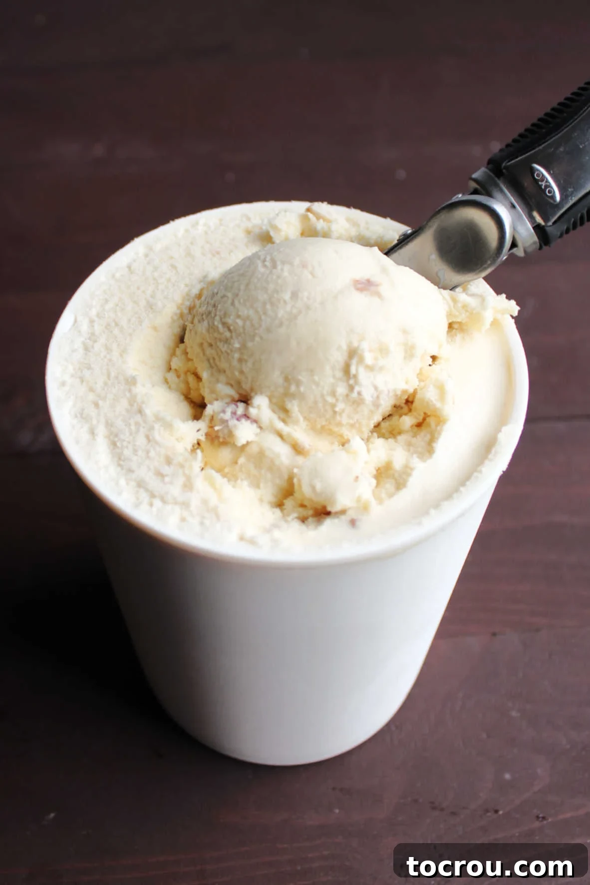 Maple Bacon Bliss Ice Cream 4 scooping out first helping of maple bacon ice cream from storage container.