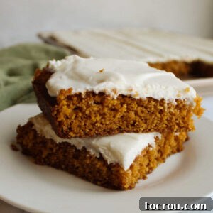 Stack of pumpkin bars with cream cheese frosting.