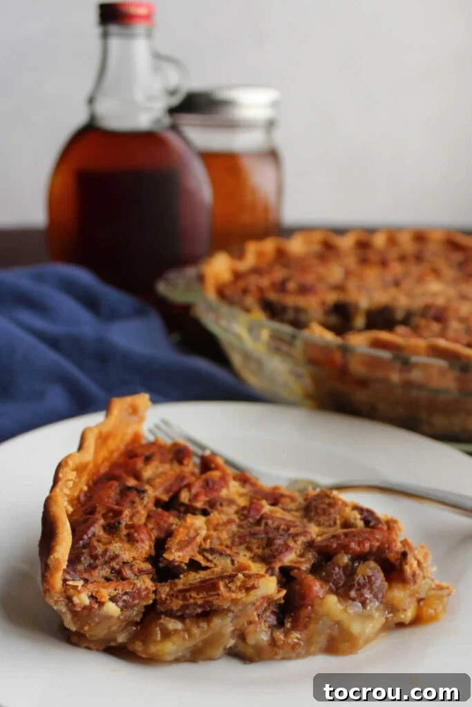 Pure Honey and Maple Pecan Pie 10 Side view of gooey honey maple pecan pie with jars of maple syrup and honey in background.