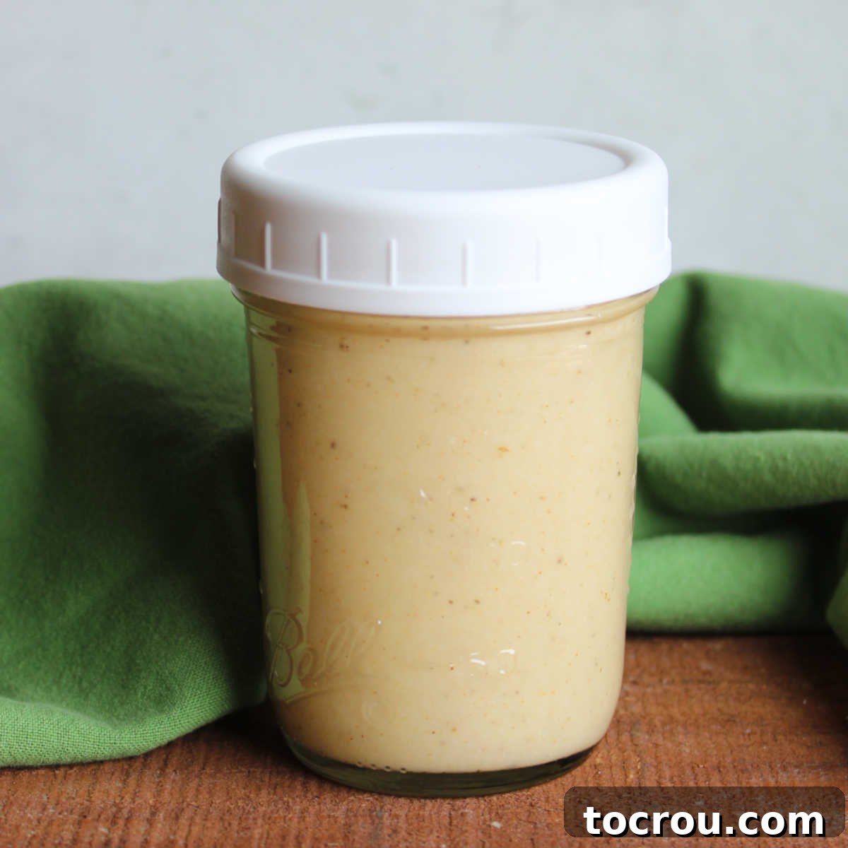 Small glass jar filled with creamy parmesan salad dressing. 