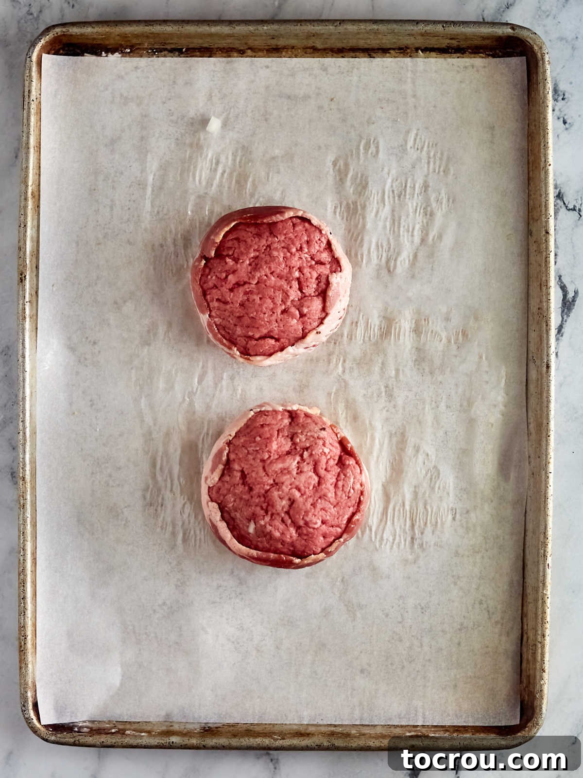 Maw-Maws Unexpected Burger Bliss 5 Two stuffed hamburger surprises wrapped in bacon, ready to be cooked. Showing meticulous preparation before hitting the grill.