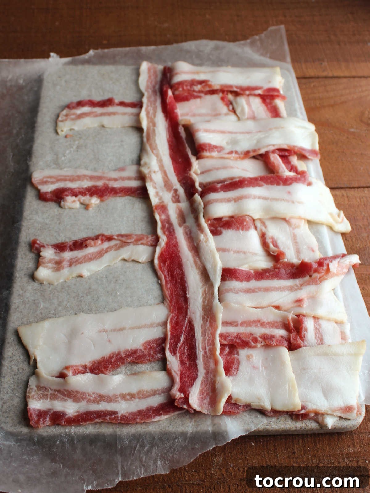 Weaving bacon slices with every other crosswise piece of bacon being folded back so a piece of bacon can be inserted going the other way.