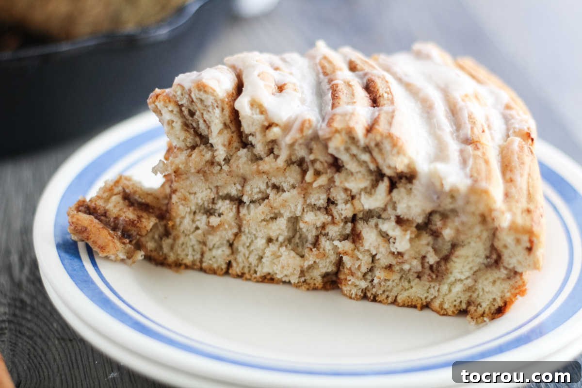 slice of skillet cinnamon roll on plate showing layers.