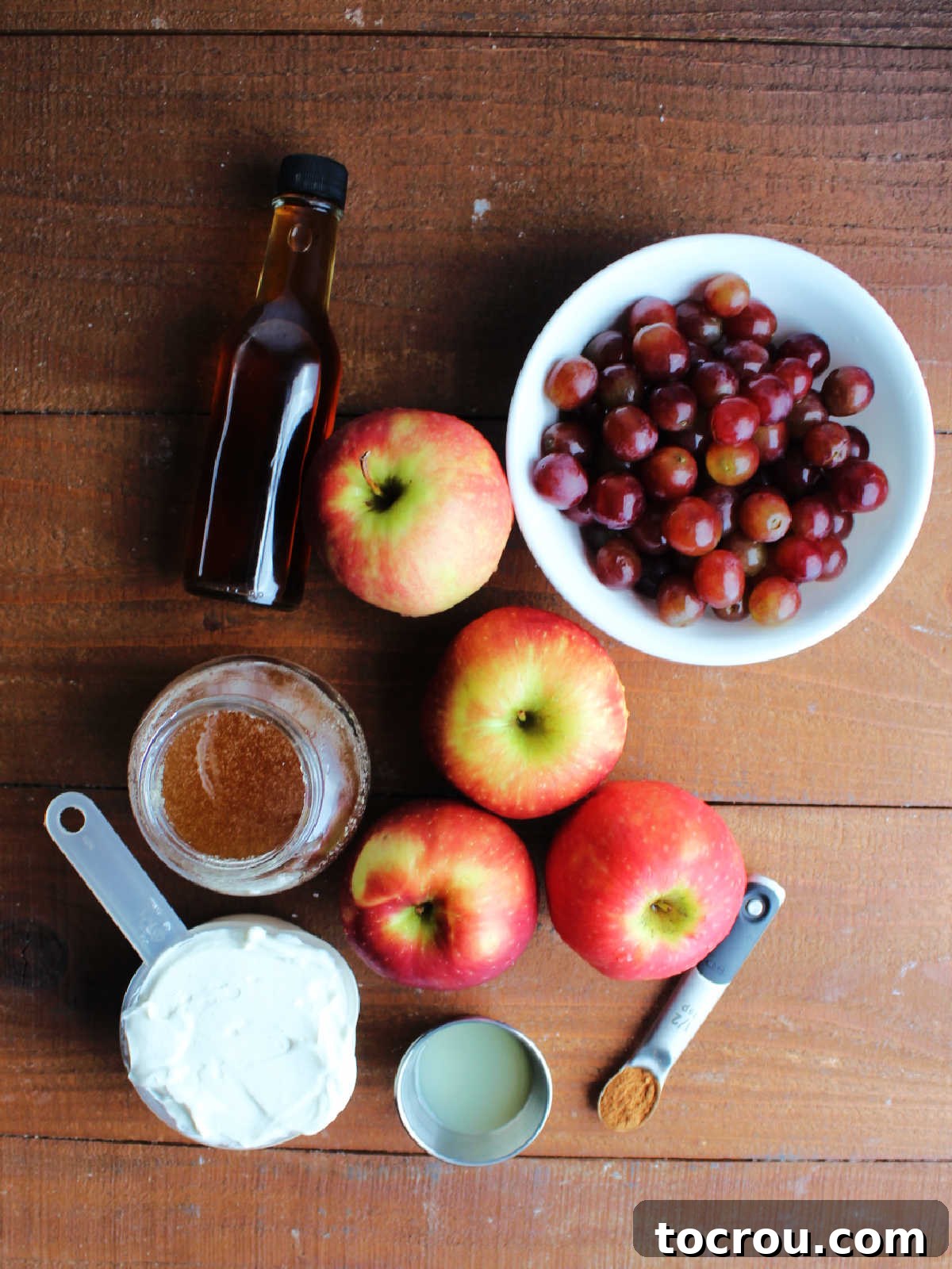 Fresh ingredients for yogurt apple grape salad. Ingredients including apples, grapes, yogurt, honey, vanilla, lemon juice, and cinnamon ready to be made into an apple salad.