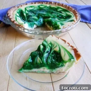 Slice of creamy pie with green swirls of kiwi in white filling.