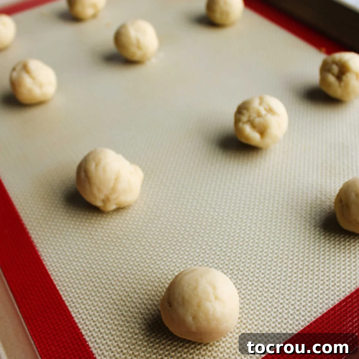 balls of sweetened condensed milk cookie dough on pan, ready to bake.