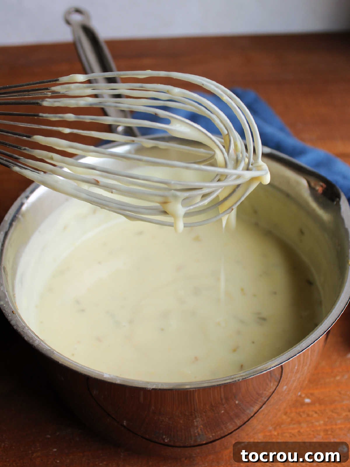 Cori's Velvety Homemade Chicken Soup 5 Thickened cream of chicken soup on whisk, ready to be transferred to storage containers or used.