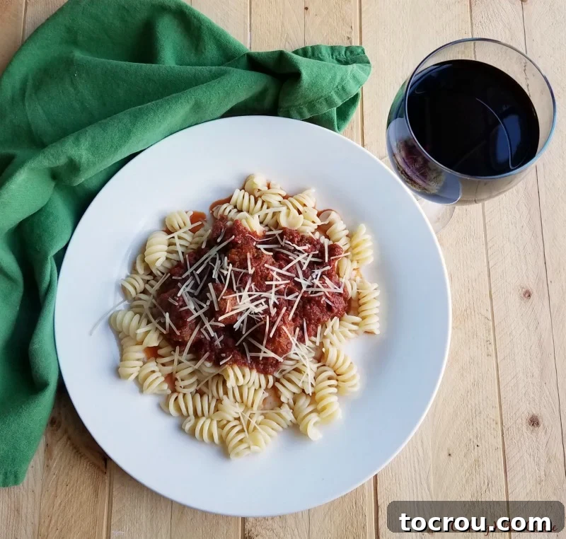 Plate of pasta topped with meatballs and tomato sauce, showcasing a delicious meal.