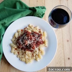 Plate of pasta topped with meatballs and tomato sauce, ready to be enjoyed.