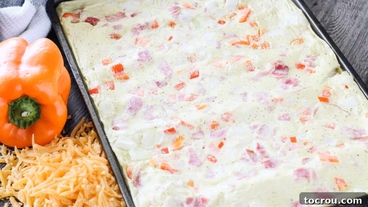 Denver Omelet Roll-Up 5 Baked sheet pan scrambled egg mixture with ham, peppers and onions baked inside.